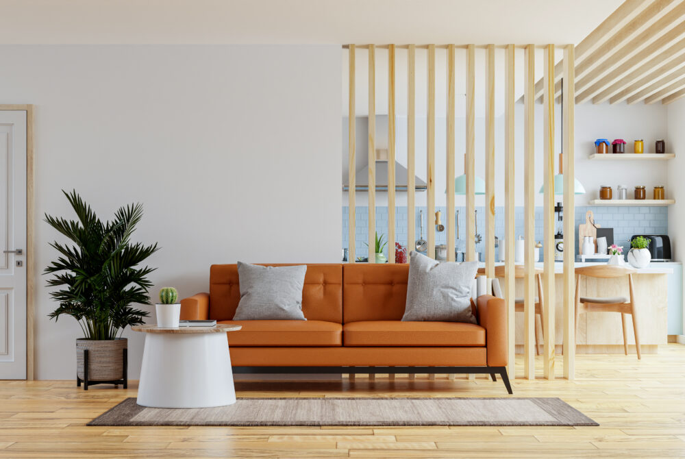 Living room interior wall mockup in warm tones with leather sofa which is behind the kitchen.3d rendering